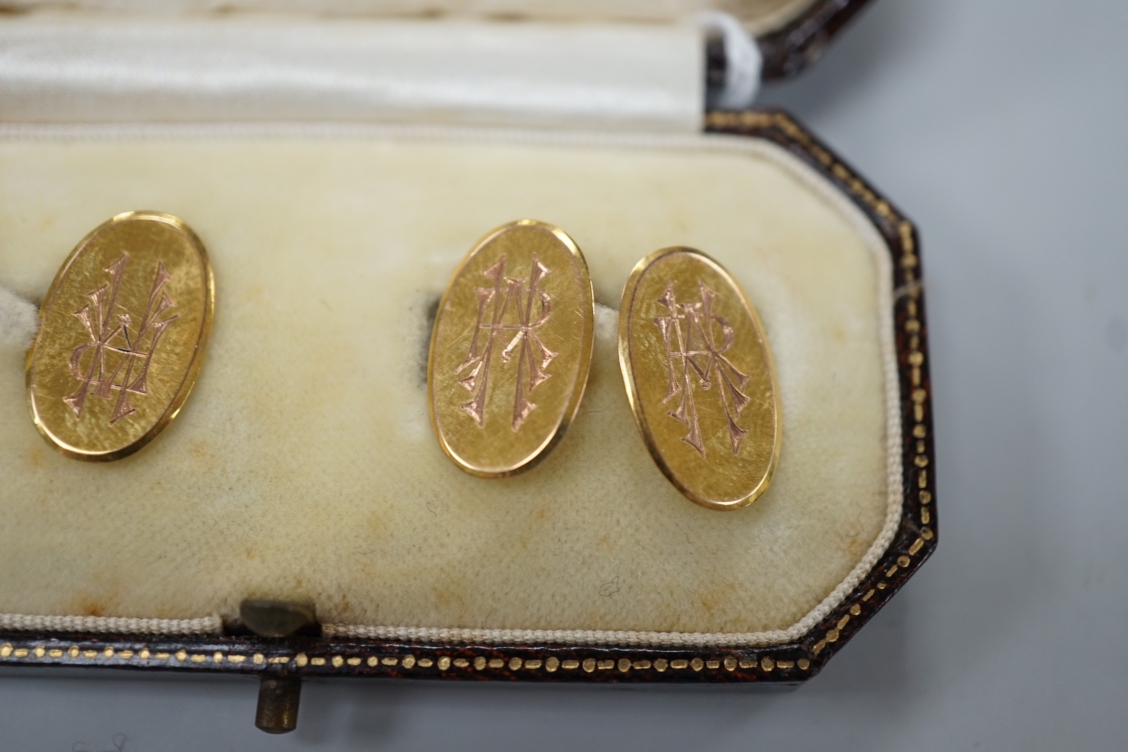 A pair of George V 9ct. gold oval cuff links, with engraved monograms, cased, 4.3 grams.